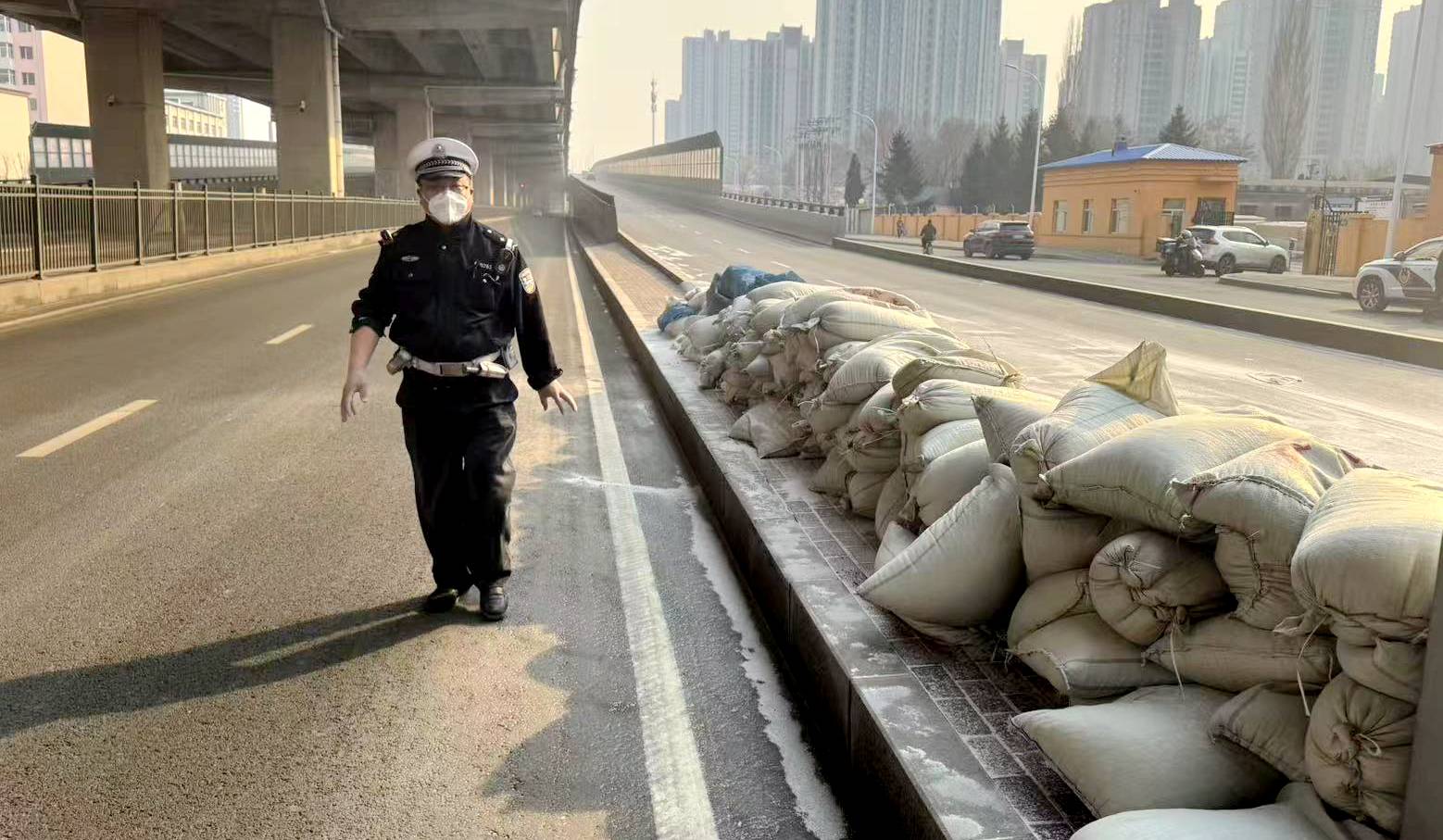 50余袋珍珠岩散落上桥口，冰城交警徒手搬运
